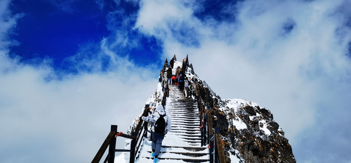 ▲游客攀登昆明轿子雪山
