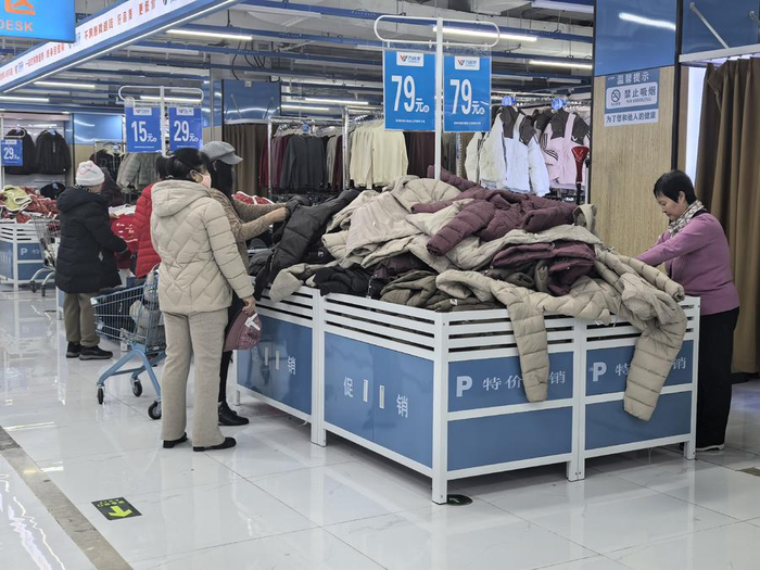 消费者在万客来超市内选购服装。