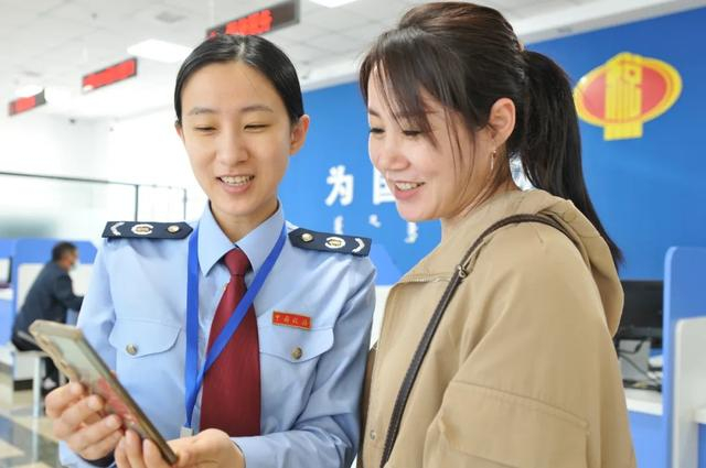 国家税务总局扎兰屯市税务局干部辅导纳税人使用电子税务局App开具发票。乔雪蕾 摄