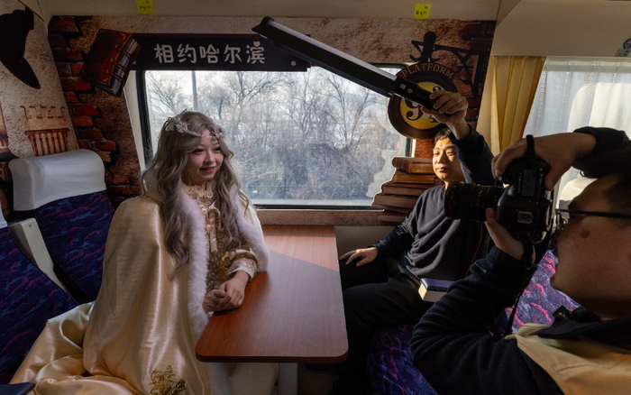 　　图为2025年1月2日，在哈尔滨开往亚布力南的K5197次列车上，摄影师给乘客拍照。新华社发（张涛摄）