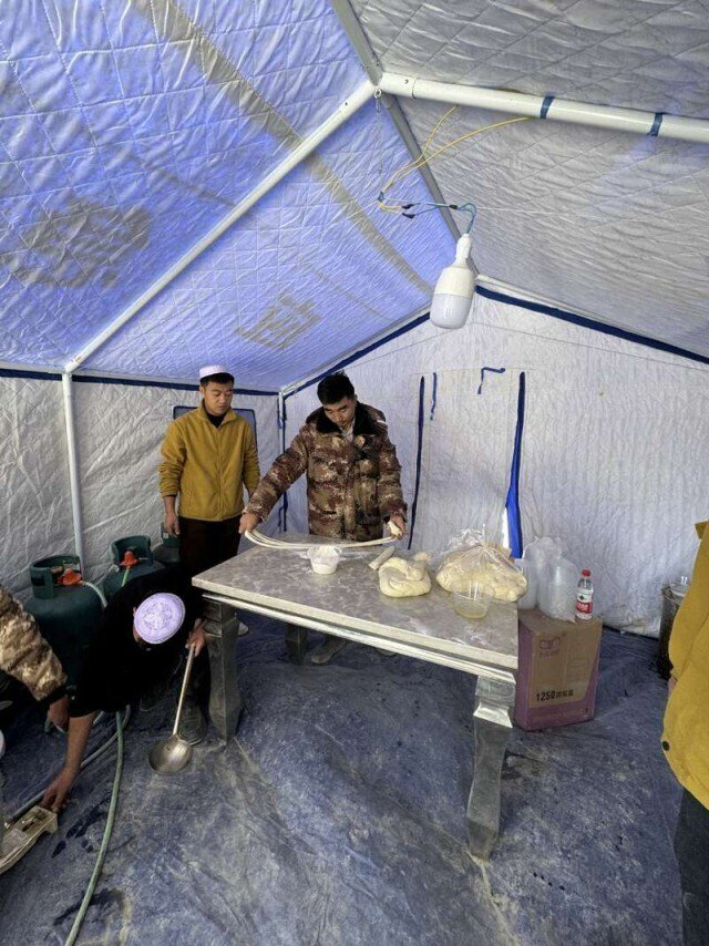 马忠明在救灾帐篷做拉面。