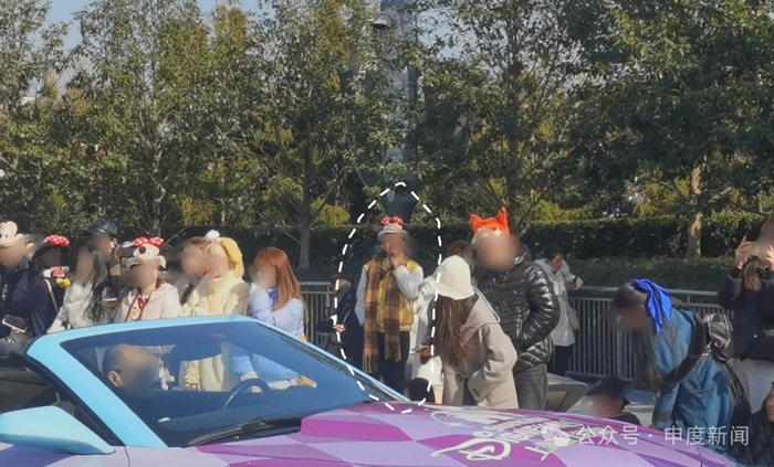 ▲吸烟者站在人群之中欣赏花车巡游