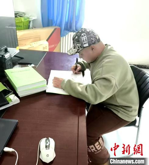 　　阿力木江在学习防沙治沙资料。张培及 摄