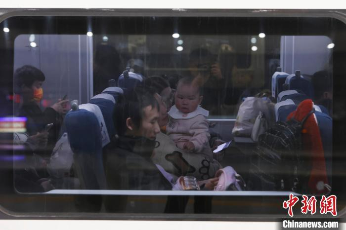 旅客带着孩子乘坐G4831次临时旅客列车前往自己的目的地。中新网记者 殷立勤 摄