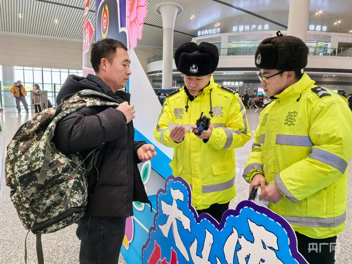 志愿者和警察在车站为旅客提供帮助  （央广网记者  丁安  摄）