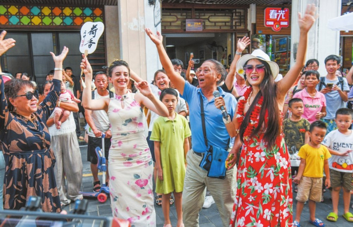 在海口骑楼老街，街头艺人演唱吸引众多市民游客参与互动，热闹非凡。 海口日报记者 康登淋 摄 