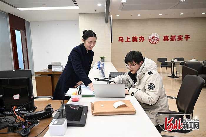 1月14日，办事群众（右）在河北省政务服务中心办理业务。 河北日报记者 田 明摄