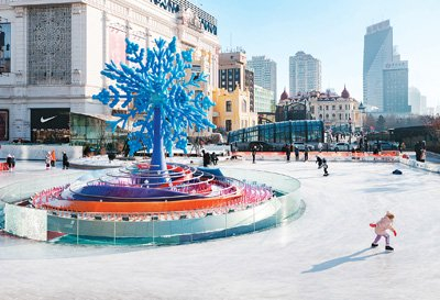 在哈尔滨市南岗区一处公益冰场，人们在“冰雪之冠”雕塑旁滑冰。新华社记者 谢剑飞摄