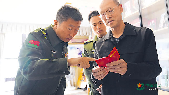 贾红新（右一）拿着自己的立功受奖证书，向年轻飞行员讲述以前执行任务的经历。侯向坤摄