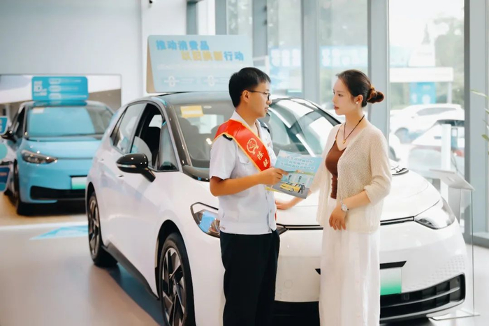 在四川，崇州市税务局干部走访汽车4S店，为消费者讲解新能源车免征车辆购置税政策，助力以旧换新。（詹晓攀/摄）