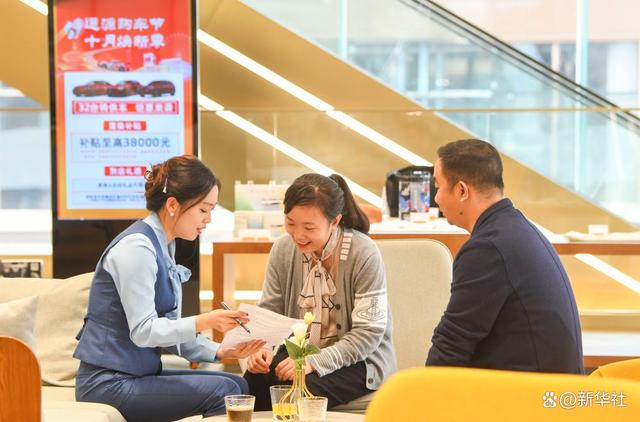 重庆市江北区北滨一路一家4S店的工作人员为消费者介绍购车补贴相关政策（2024年10月17日摄）。 新华社记者 王全超 摄