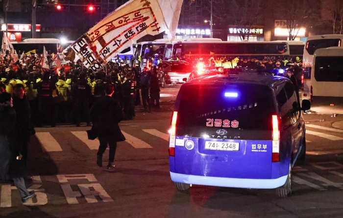 当地时间2025年1月18日，韩国首尔，一辆蓝色厢型车被认为是运送总统尹锡悦离开首尔西部地方法院 视觉中国