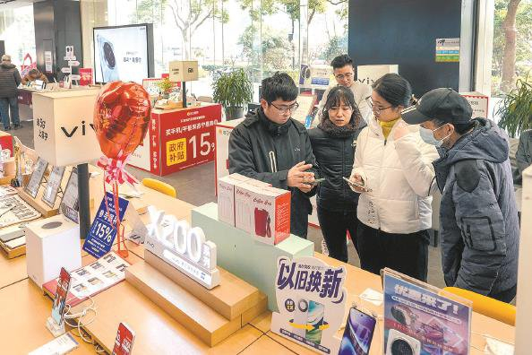             今天是手机等三类数码产品加入“国补”的首日，在苏宁五角场店，15%的优惠吸引了不少顾客前来咨询、购买  本报记者  陈梦泽  摄          