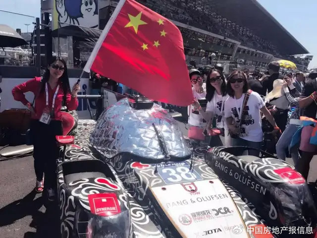 姚启明在法国勒芒萨尔特赛道上为中国车队举旗庆祝。