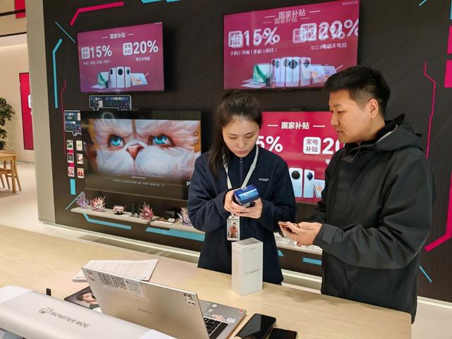 图说：周先生成为荣耀北外滩来福士门店购买手机享受国补的第一单客户 来源/叶薇 摄