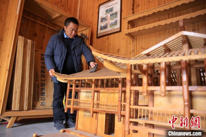  贺茂宣在土家族吊脚楼模型上研究建造工艺。杜迪纳 摄