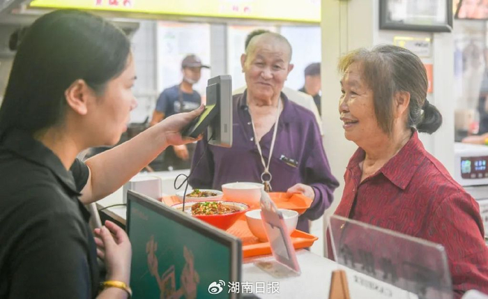 道县濂溪街道良田社区“惠民食堂”助餐点，老年人在进行餐前登记。蒋克青 摄