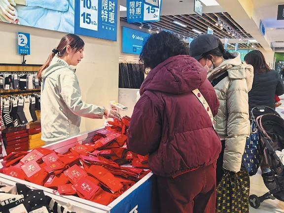 每逢新春佳节，服装市场总是格外红火。图为消费者在选购红袜子。