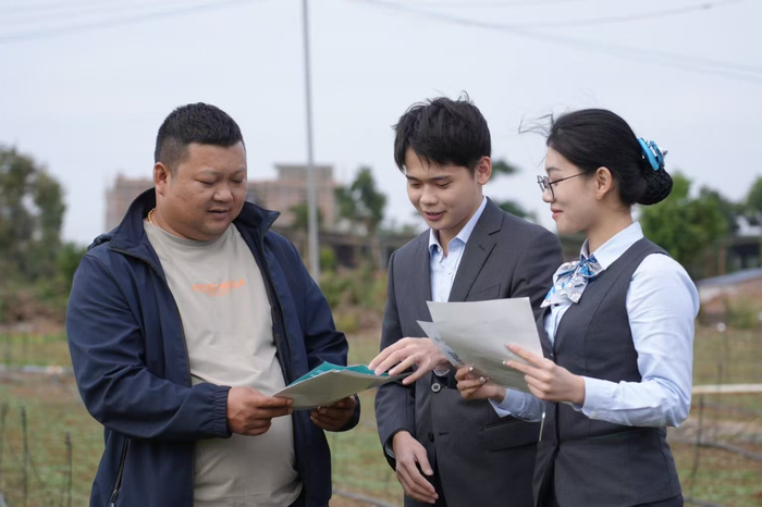 图为农行广东湛江徐闻支行员工深入田间地头，为客户介绍“惠农e贷”产品。