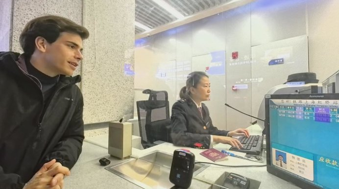 　　上海铁路虹桥站售票员游园服务外籍旅客购票。采访对象供图