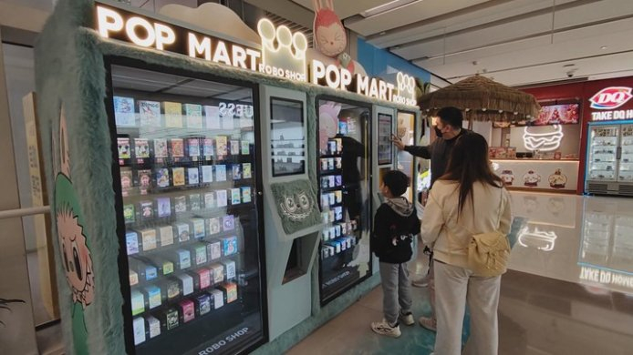 　　2025年1月，泰国游客在上海世茂广场的一个泡泡玛特自助售货机前选购盲盒。新华社记者张梦洁 摄