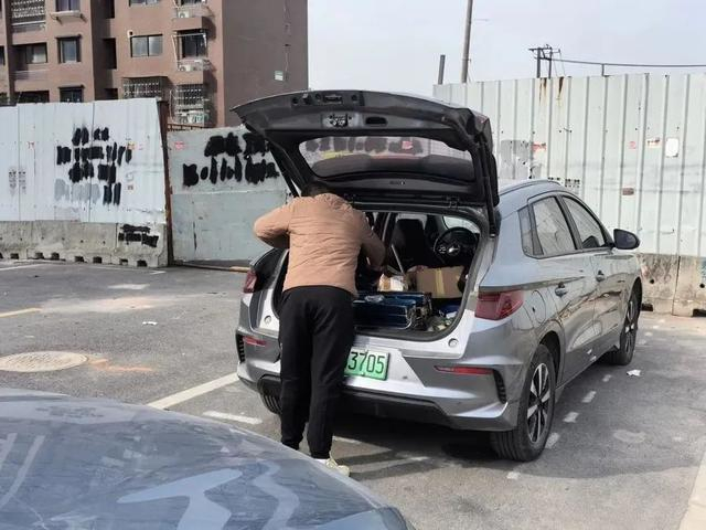 △小米正在从装满各种线束的比亚迪后备箱里挑选改装的全套配件。