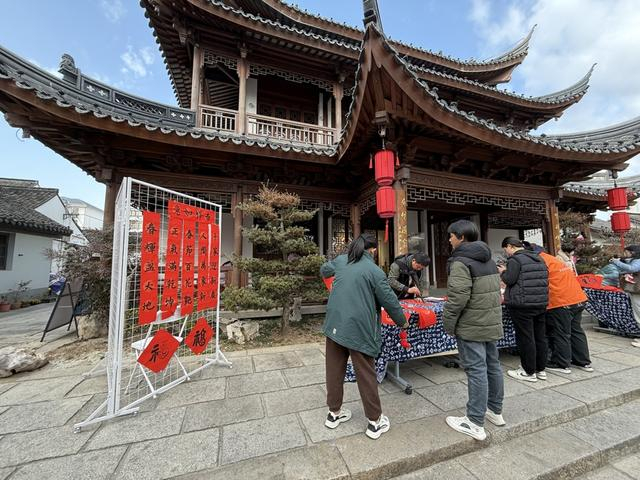 市民观众在青溪老街“村晚”场外体验写春联等民俗活动。沈思怡 摄