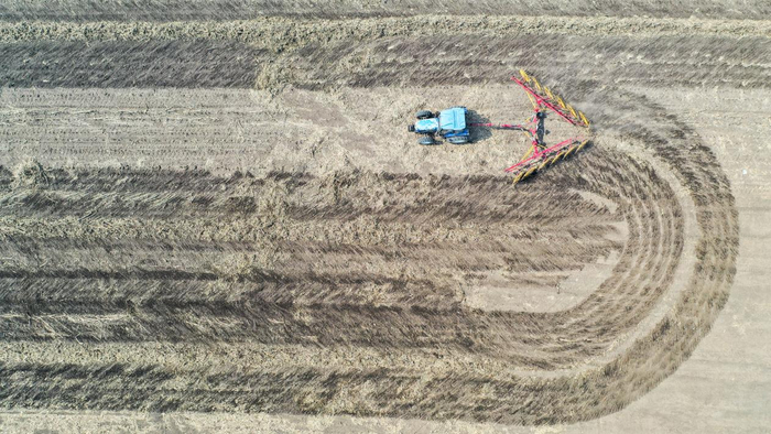 2024年4月2日，农民在吉林省公主岭市范家屯镇驾驶农机整理耕地里的秸秆（无人机照片）。新华社记者 张楠 摄