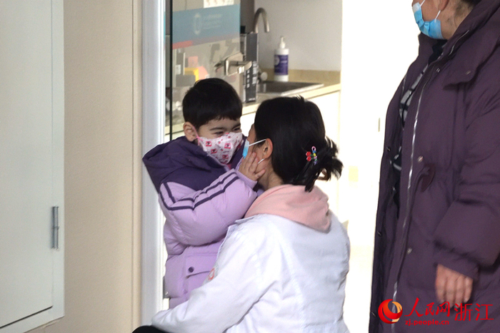 即将分别，小依依捧起了赵妈妈的脸。人民网 陈陆洵摄