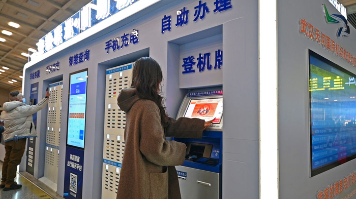 图为旅客在汉口站候车室打印登机牌。 （国铁武汉局供图）