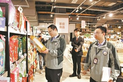 在番禺区奥园广场华润万家超市，工作人员对米、油等食品进行抽检。