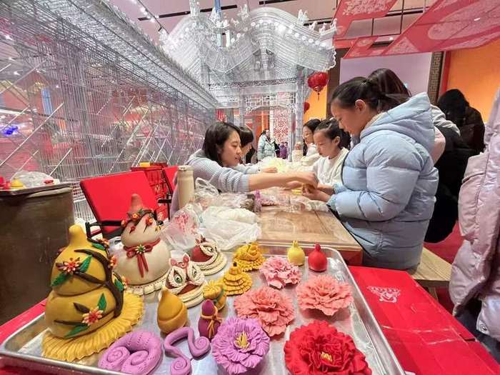 “过年——春节主题展”，小朋友在体验区学习制作花馍。新京报记者 王飞 摄