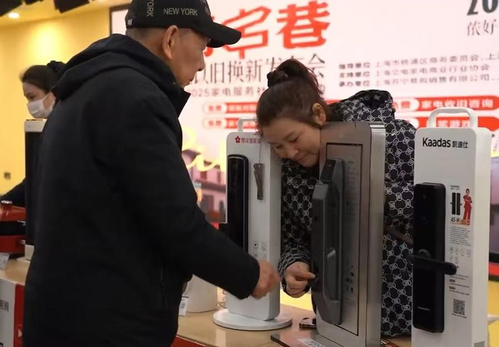 工作人员现场为居民讲解智能锁产品。