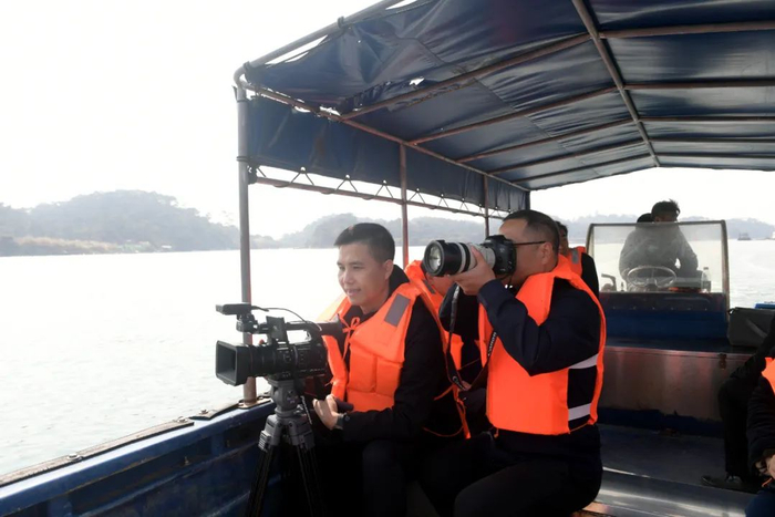 记者乘船出海拍摄新闻素材。