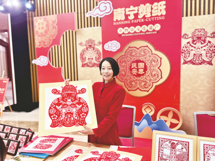钟昀睿展示今年最新创作的南宁剪纸“财神窗花”。记者 郭少东 摄