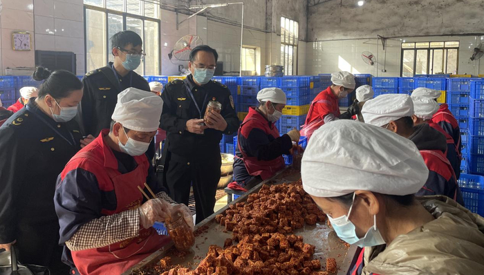 执法人员在豆腐乳包装车间检查。李诚明/摄