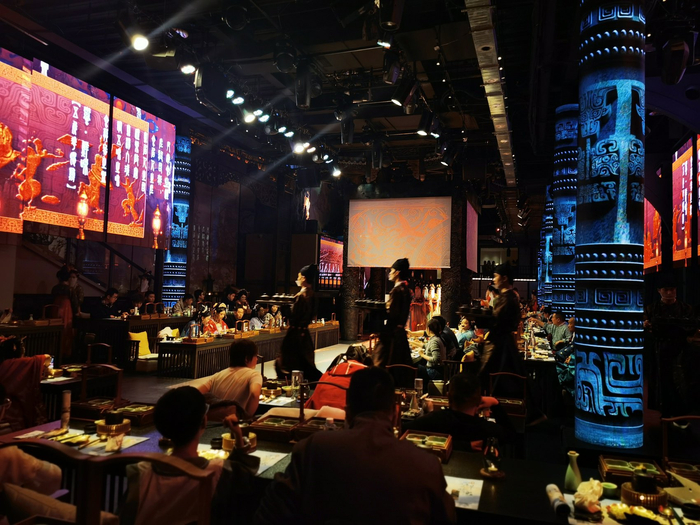 身着汉服的工作人员正在为顾客们上菜。