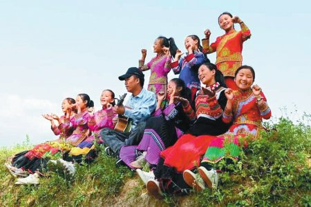 吉布小龙弹着吉他，与孩子们在山野间放歌。受访者供图