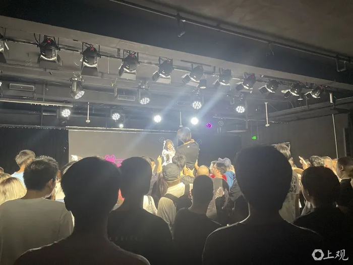 在地偶演出现场,一位粉丝被托起向舞台“起飞”。金颖 摄