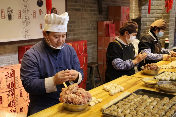 谷小光和工人们一起制作棋子烧饼。本报记者 苏悦 摄