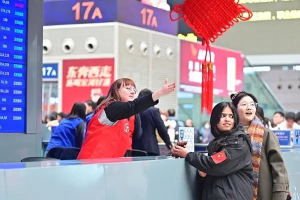 1月22日，郑州东站，留学生在春运志愿服务中。王玮/摄