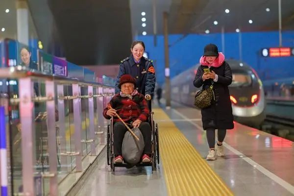 1月24日，南京南站“158”雷锋服务站客运值班员吴晓娟协助重点旅客出行。李忱/摄