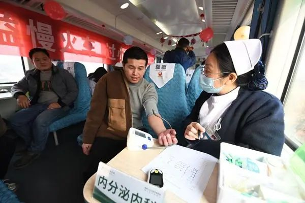 1月23日，中国铁路武汉局集团有限公司组织专家医生在6025次公益慢火车上为旅客义诊。彭琦/摄