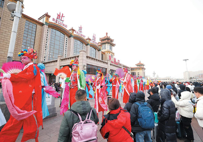 1月26日，北京站站前广场，旅客驻足欣赏高跷秧歌表演。新京报记者 王贵彬 摄
