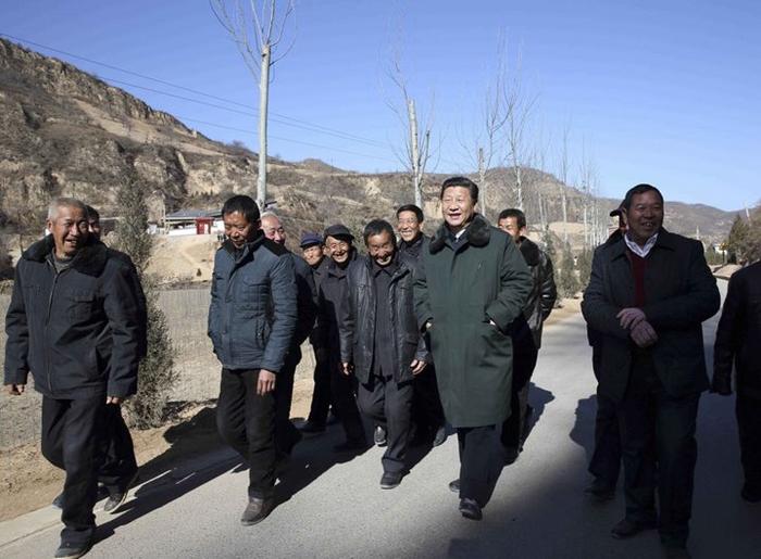 2015年2月13日，农历羊年春节来临之际，习近平在陕西延安市延川县文安驿镇梁家河村调研时同村民边走边聊。