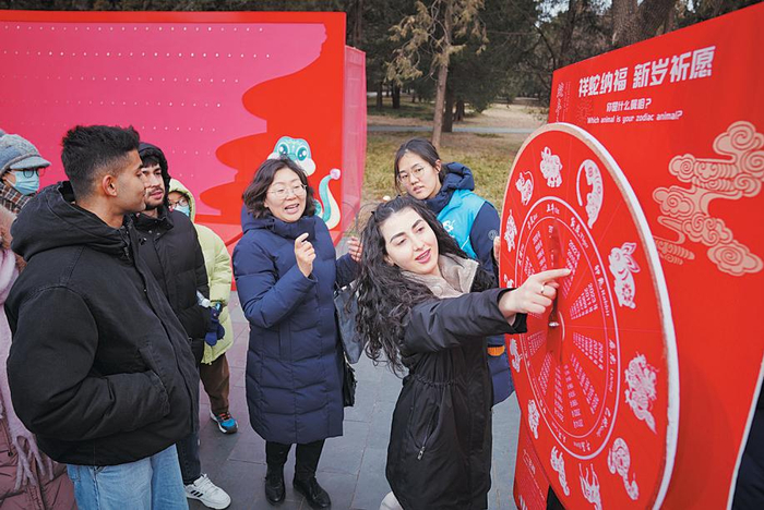 1月26日，天坛公园，一位外国游客在十二生肖转盘上找到自己的属相。 新京报记者 薛珺 摄