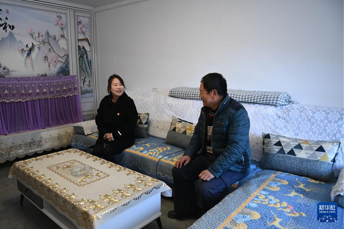 1月8日，陕西省宝鸡市凤县坪坎镇银母寺村党支部书记张侠侠（左）在村民家走访。新华社记者 李一博 摄