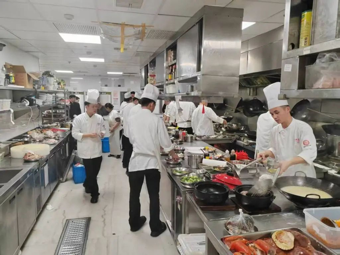 上海老饭店后厨，厨师们在准备年夜饭的菜品。受访者供图