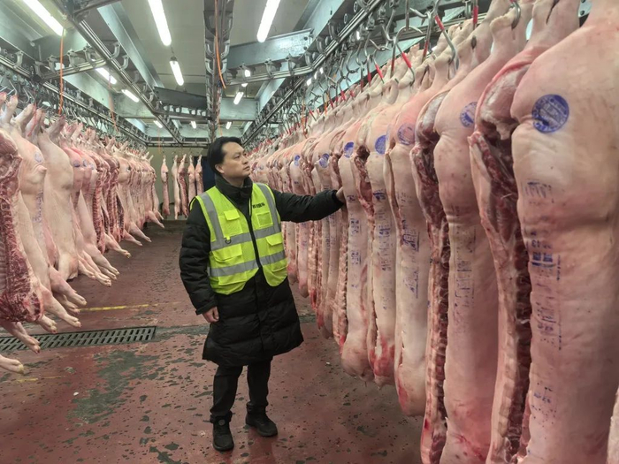 张伟栋在市场检验每一片入场交易的猪肉。