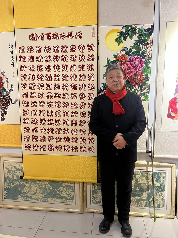 高佃亮与他设计的《百蛇祥瑞图》。新京报贝壳财经记者 张晗 摄